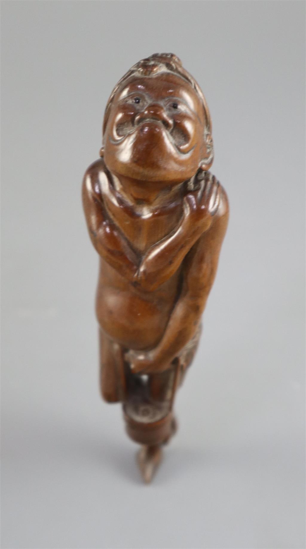 A Japanese cherrywood okimono netsuke of a farmer, early 19th century, 15cm long